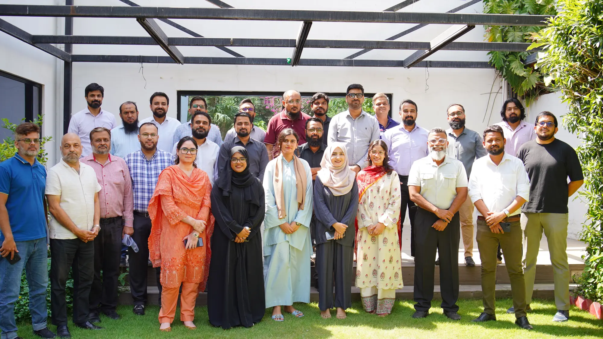 The Amreli Steels leadership group posed together on a lawn outside the office after the session.